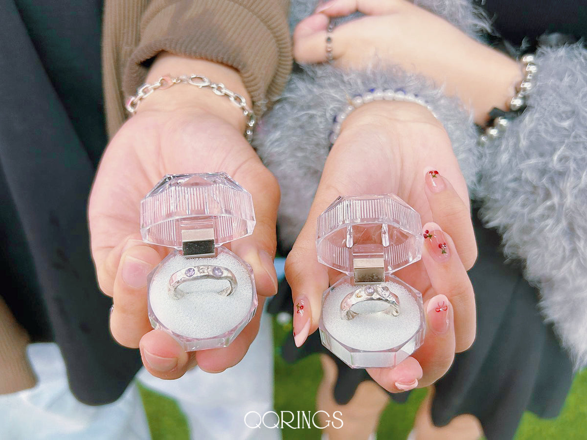 Two hands delicately holding open ring boxes with custom-made silver rings, showcasing creativity and personal touch from a couple's jewelry workshop. #Handcrafted #CoupleRings